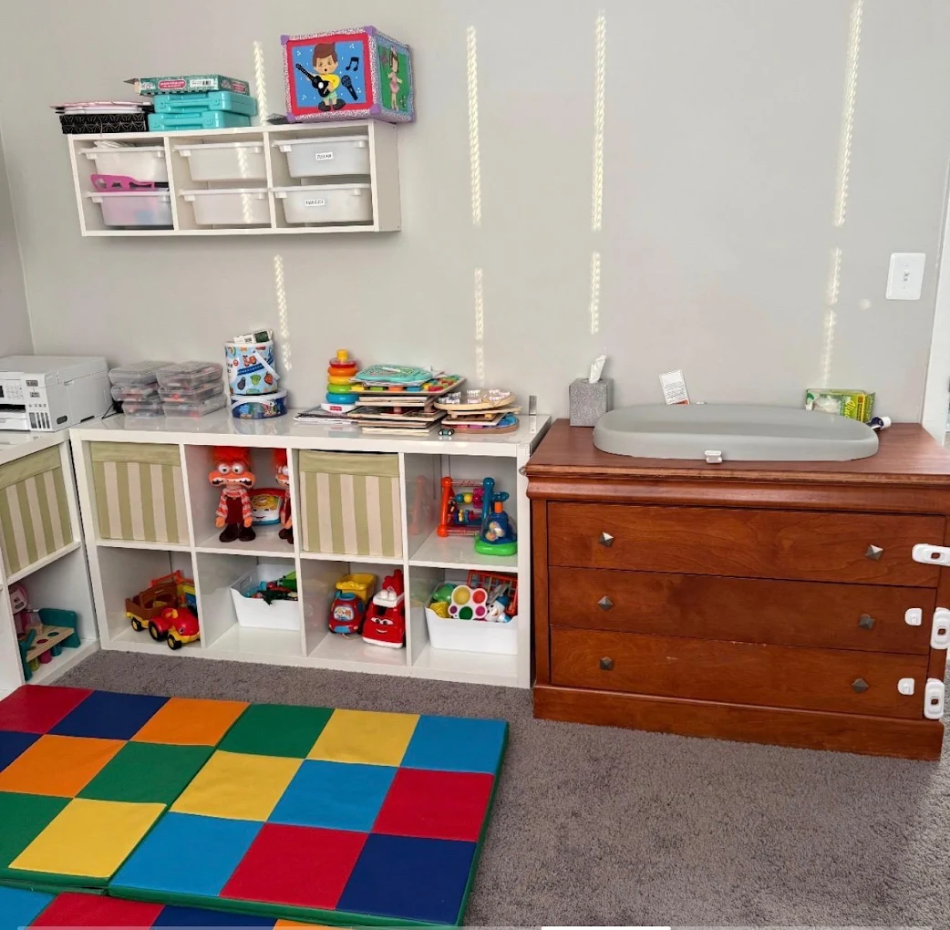 Organized activity area with toys, books and a colorful floor mat