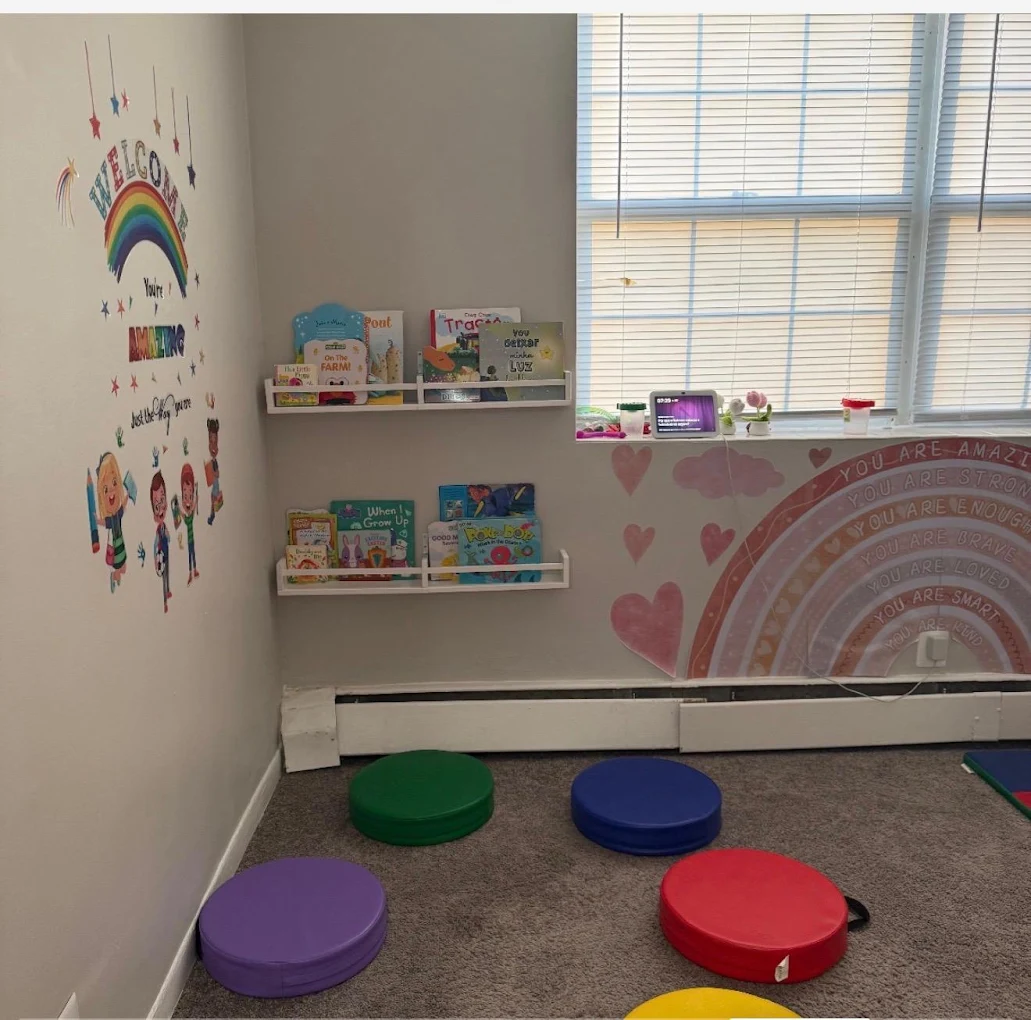 Reading corner with children's books, colorful floor cushions and wall decorations